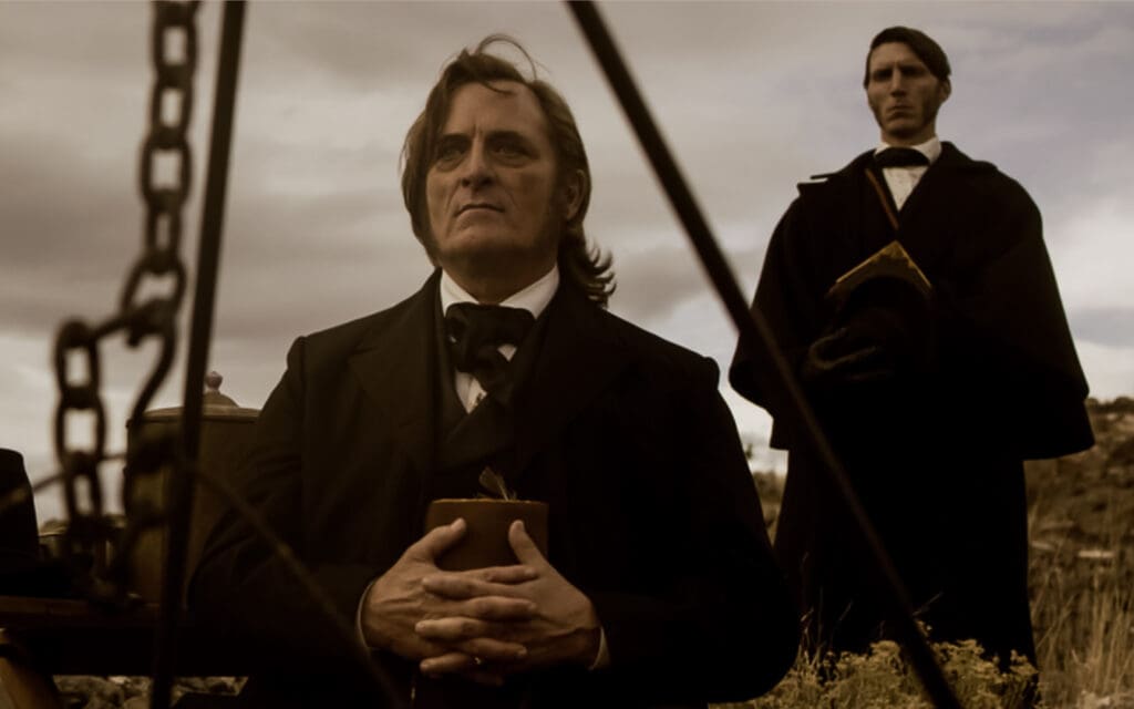 (L to R) Kim Coates as Brigham Young and Alex Breaux as Wild Bill Hickman in American Primeval.