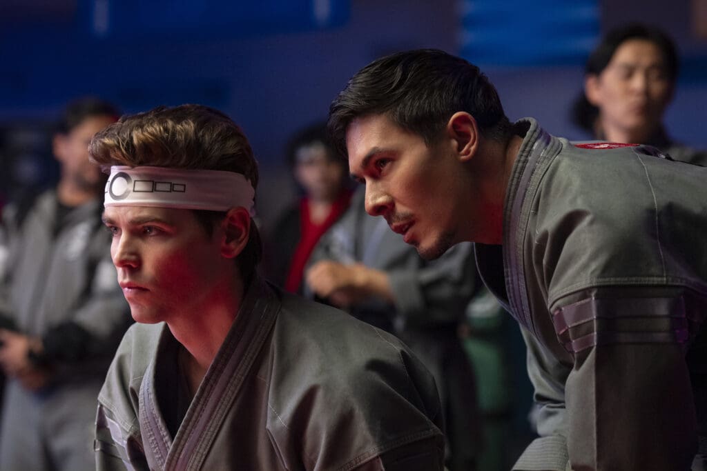 (L to R) Patrick Luwis as Axel, Lewis Tan as Sensei Wolf in Cobra Kai.