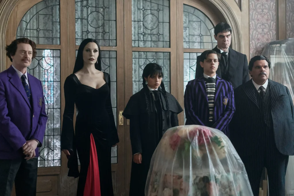 (L to R) Steve Buscemi as Barry Dort, Catherine Zeta-Jones as Morticia Addams, Jenna Ortega as Wednesday Addams, Isaac Ordonez as Pugsley Addams, Joonas Suotamo as Lurch, Luis Guzma?n as Gomez Addams in Wednesday.