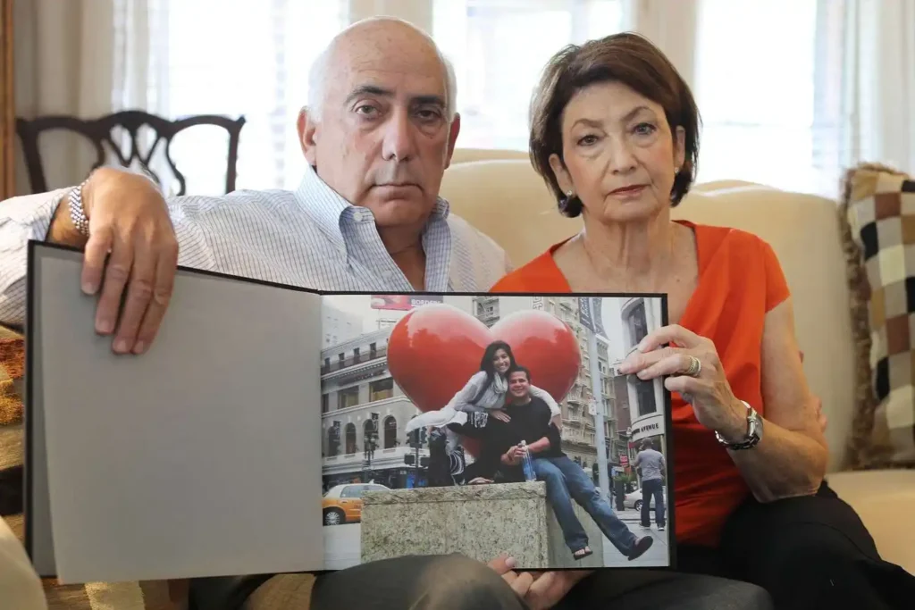 Josh and Sandee Greenberg holding a picture of daughter Ellen Greenberg and her fiance