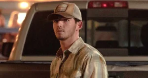 Finn Little as Carter standing in front of a pickup truck bed in an episode of Dutton Ranch