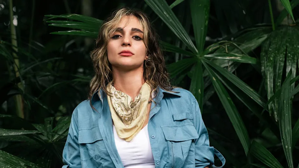 A portrait of Sarah Awad, a contestant from Outlast Season 3: The Jungle, standing in a jungle