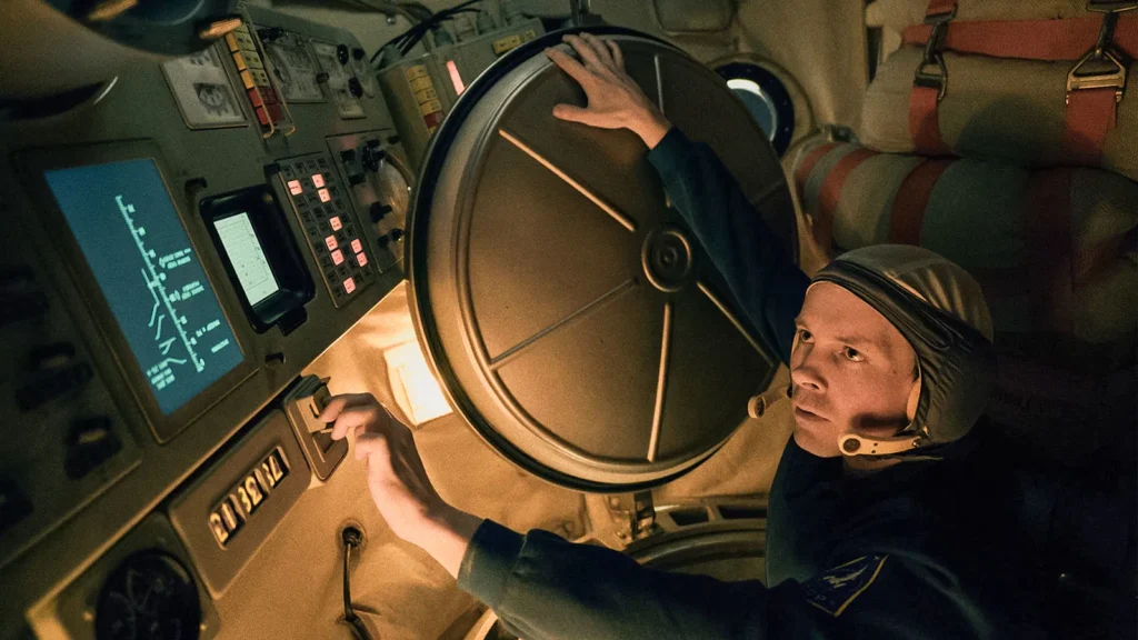 A Soviet cosmonaut inside a cramped, dimly lit rocket capsule in Star City Season 1, Episode 3