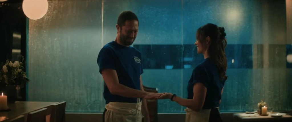 Richie and Jess in the middle of the dining room in The Bear Season 5, with Jess touching Richie's hand in an intimate moment between them