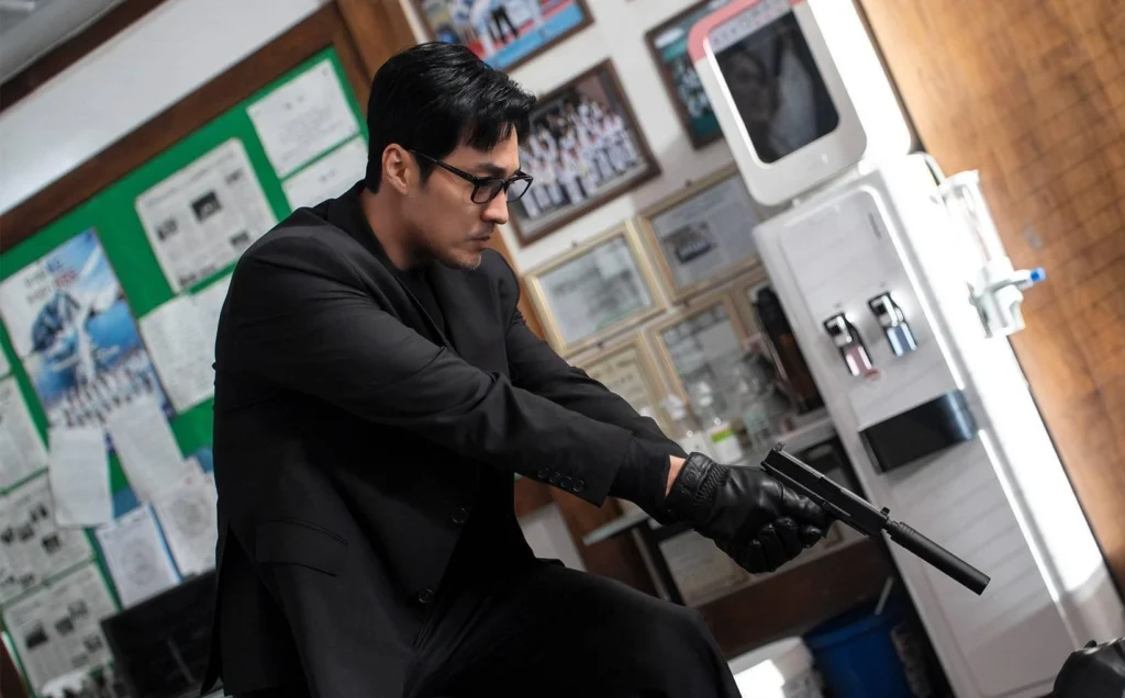 So Ji-sub as Manager Kim wearing glasses and a suit while aiming a silenced handgun in Agent Kim Reactivated Season 1