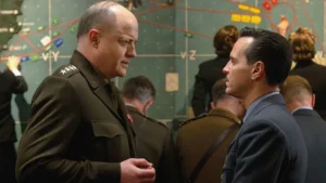 Brendan Fraser as General Dwight D. Eisenhower and Andrew Scott as James Stagg speaking face-to-face in front of a war map in Pressure