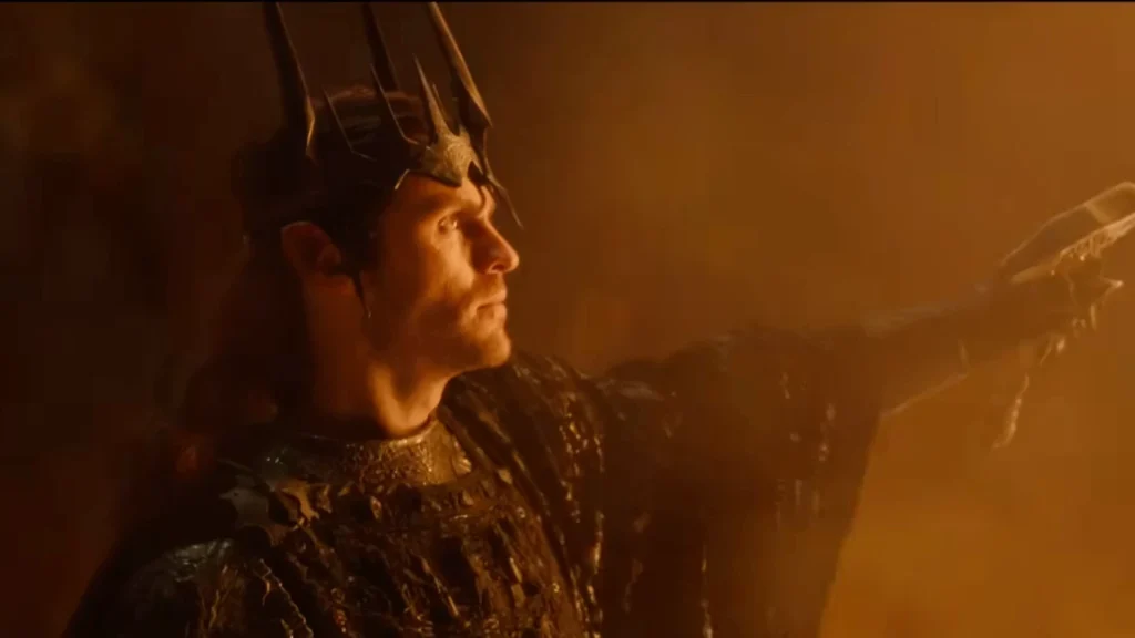 Charlie Vickers as Sauron wearing the jagged Crown of Morgoth in a warm, amber-lit forge in The Rings of Power